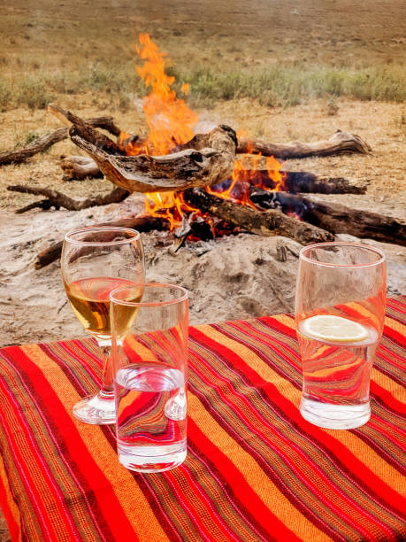 Oserengoni Wildlife Reserve, Naivasha,Kenya.Three glasses placed on an outdoor table with Maasai blanket, during the sunset drink.